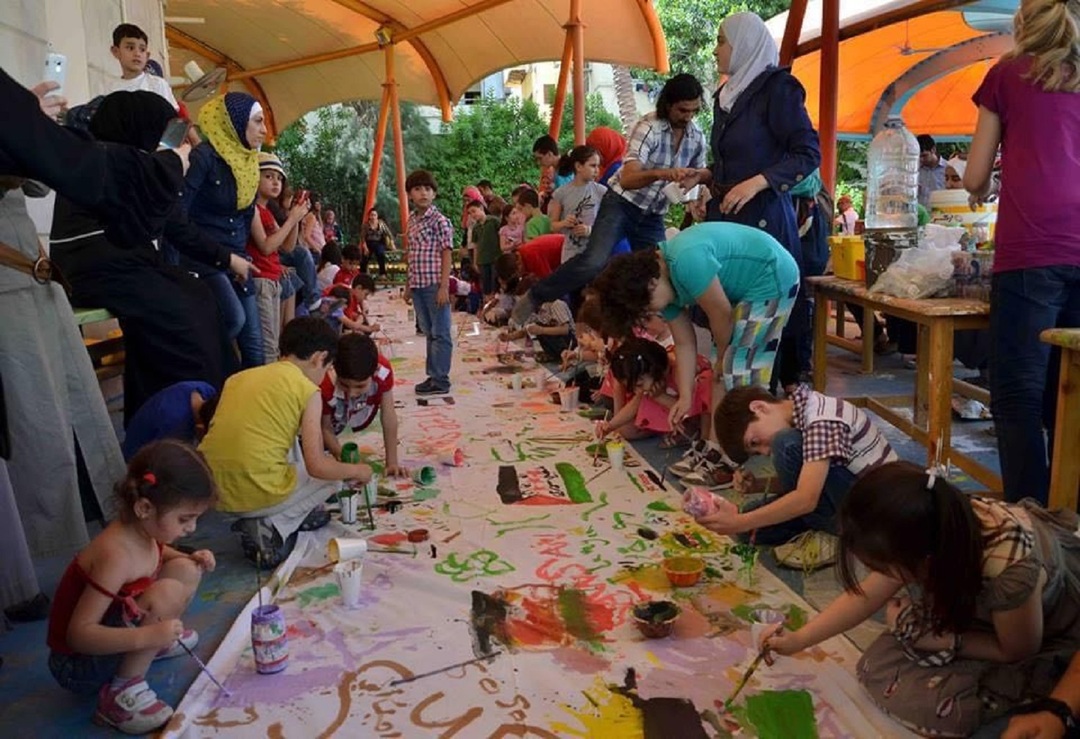عبد الكريم الحسن...فنان تشكيلي لاجئ في ألمانيا يعمل مع الأطفال على لوحة لدخول غينيس